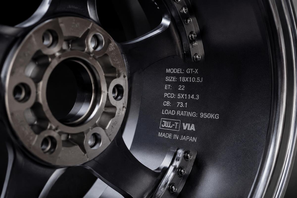 Close up of wheel bolt pattern and load rating marking engraved on the inner barrel of a two-piece racing wheel
